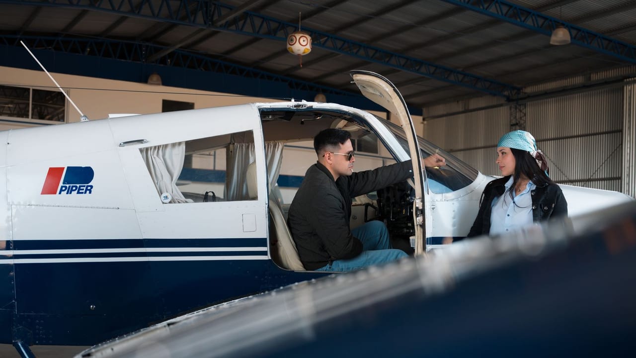 An instructor and a student talking beside a light aeroplane in a hangar
