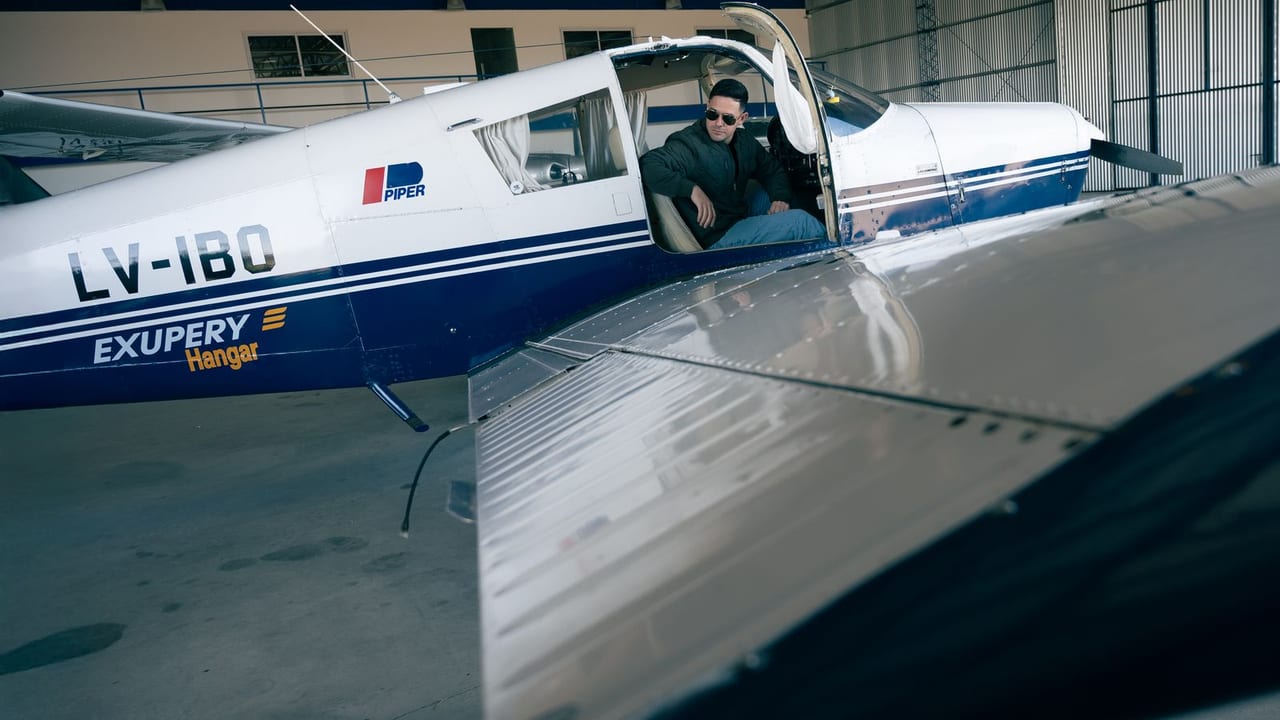 A pilot sitting in the left seat of a Piper in a hangar before a flight