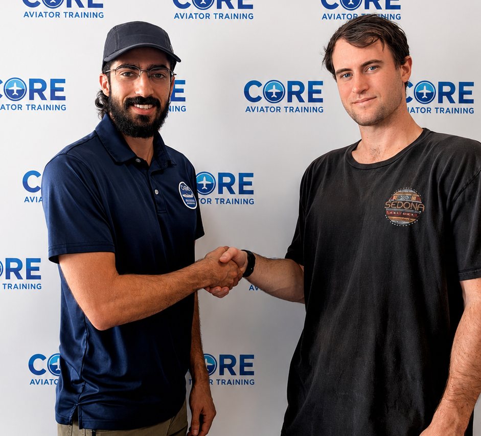 Flight instructor shaking hands with student pilot Jack in front of a Core Aviator Training backdrop